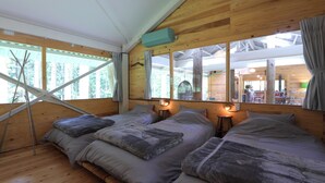 A cabin with two beds, a window with curtains, a hanging chair, and a view of the forest. - Morinonakano Kissatooyado Morikurasu (Maniwa)