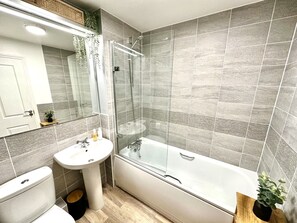 Een haardroger, handdoeken, zeep, toiletpapier