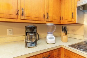 A kitchen with wooden cabinets, a coffee maker, a blender, and a knife block. - Family-Friendly Near Fort Benning! Crimson Ranch (Columbus)