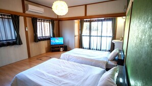 A hotel room with two beds, a television, a sink, and a window with curtains. - Alloggio Nanki Shirahama (Shirahama)