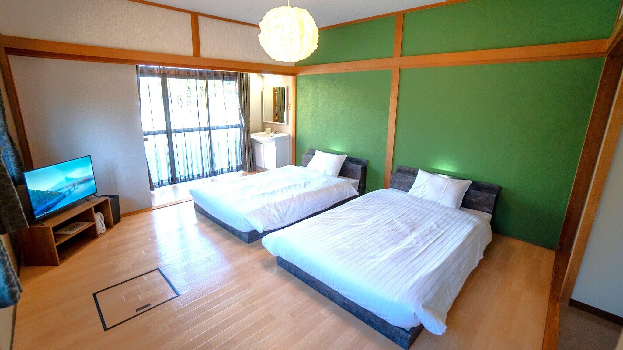 A hotel room with two beds, a television, and a bathroom.