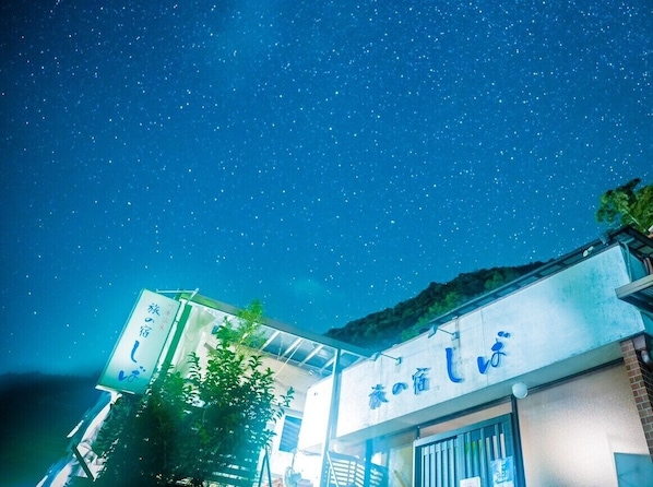 A building with signage in a foreign language, under a starry night sky.