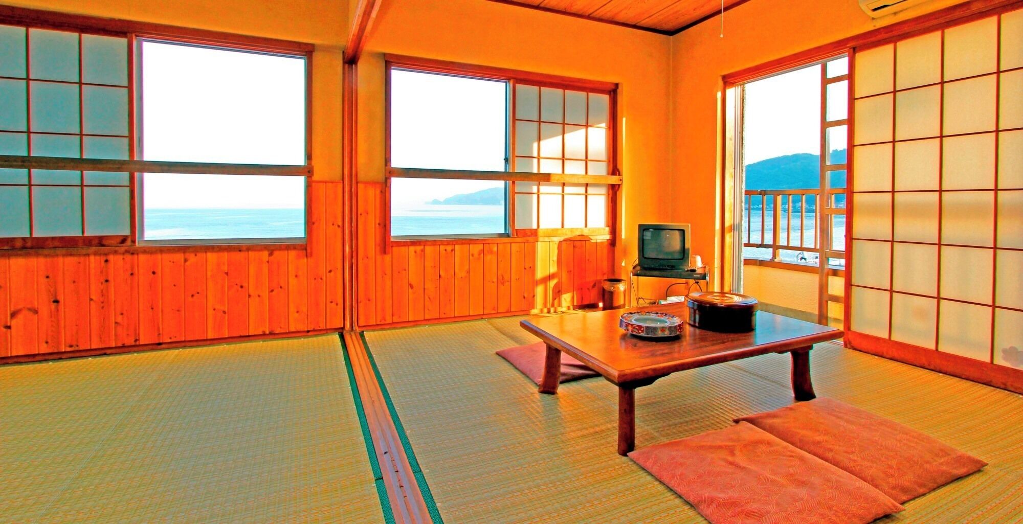 A traditional Japanese room with tatami flooring, a low table, and sliding doors.
