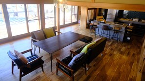 A spacious kitchen with a dining area, wooden flooring, and large windows. - Daigo-sauna (Daigo)