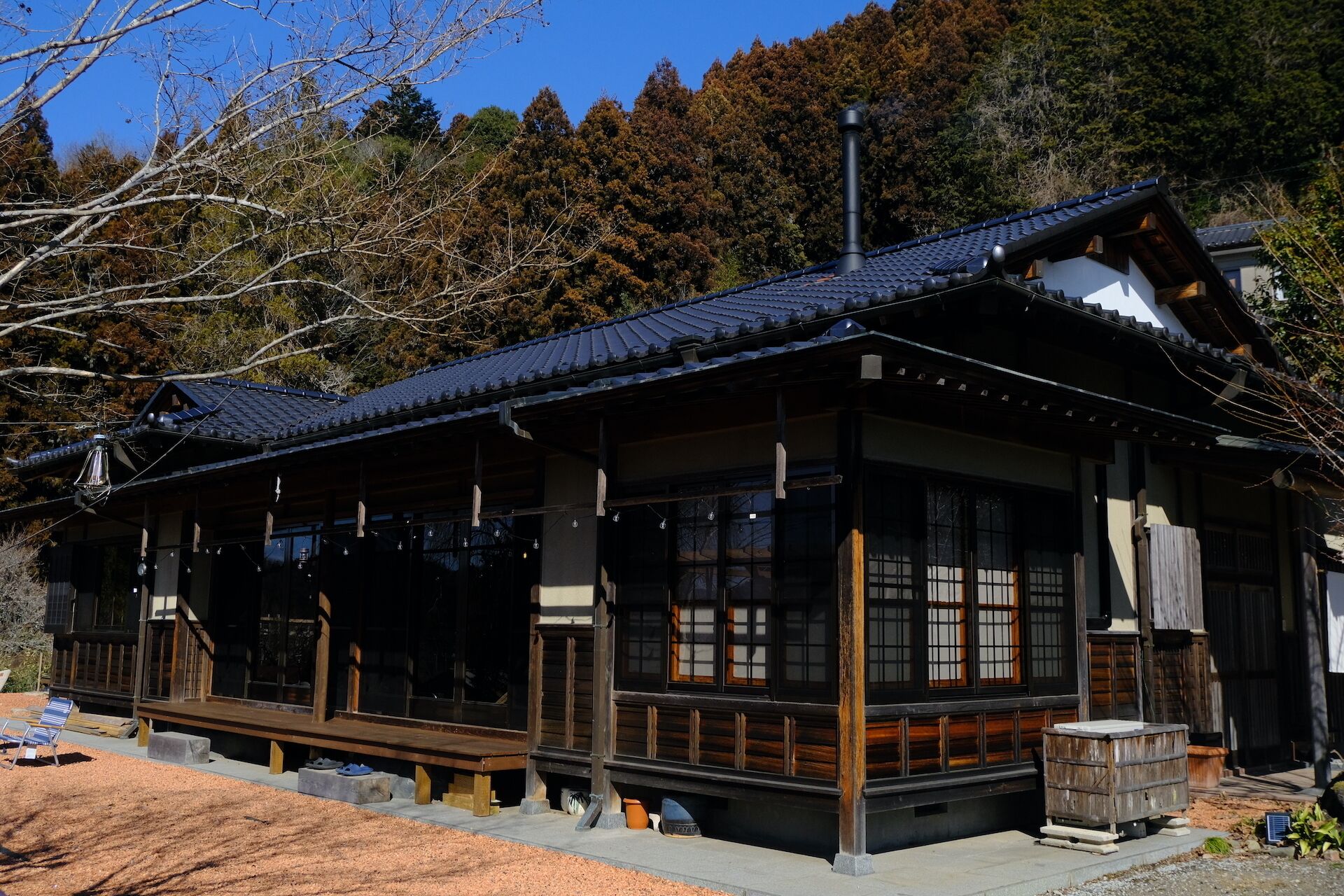 A traditional Japanese-style building with a wooden exterior, large windows, and a tiled roof.