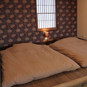 A room with a bed, a window with bars, and patterned wallpaper. - Izukogen Hanairotei (Ito)
