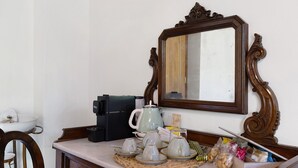 A kitchen counter with a coffee maker, teapot, cups, and a mirror. - Spacious Double Room Surrounded by Nature (Vicchio)