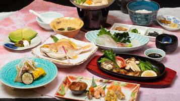 A variety of dishes on a table, including sushi, sashimi, and other Japanese cuisine.
