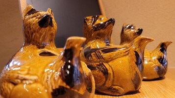 Tre vasi a forma di animali in ceramica su un piano di legno.