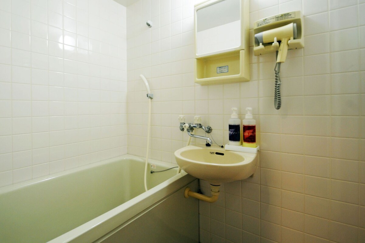 Un baño con bañera, lavamanos y espejo.