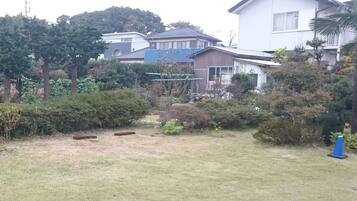A residential area with houses, a grassy yard, and some trees.