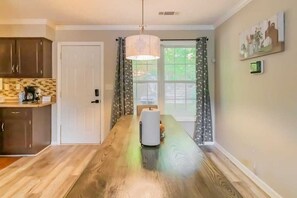 A kitchen with wooden flooring, a white door, and a dining table. - Mins to Fort Benning! Two-Story Oasis, Moore Bliss (Columbus)