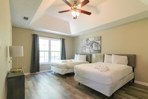 A bedroom with two beds, a ceiling fan, a window with curtains, and a wall-mounted artwork. - Mins to Fort Benning! Two-Story Oasis, Moore Bliss (Columbus)