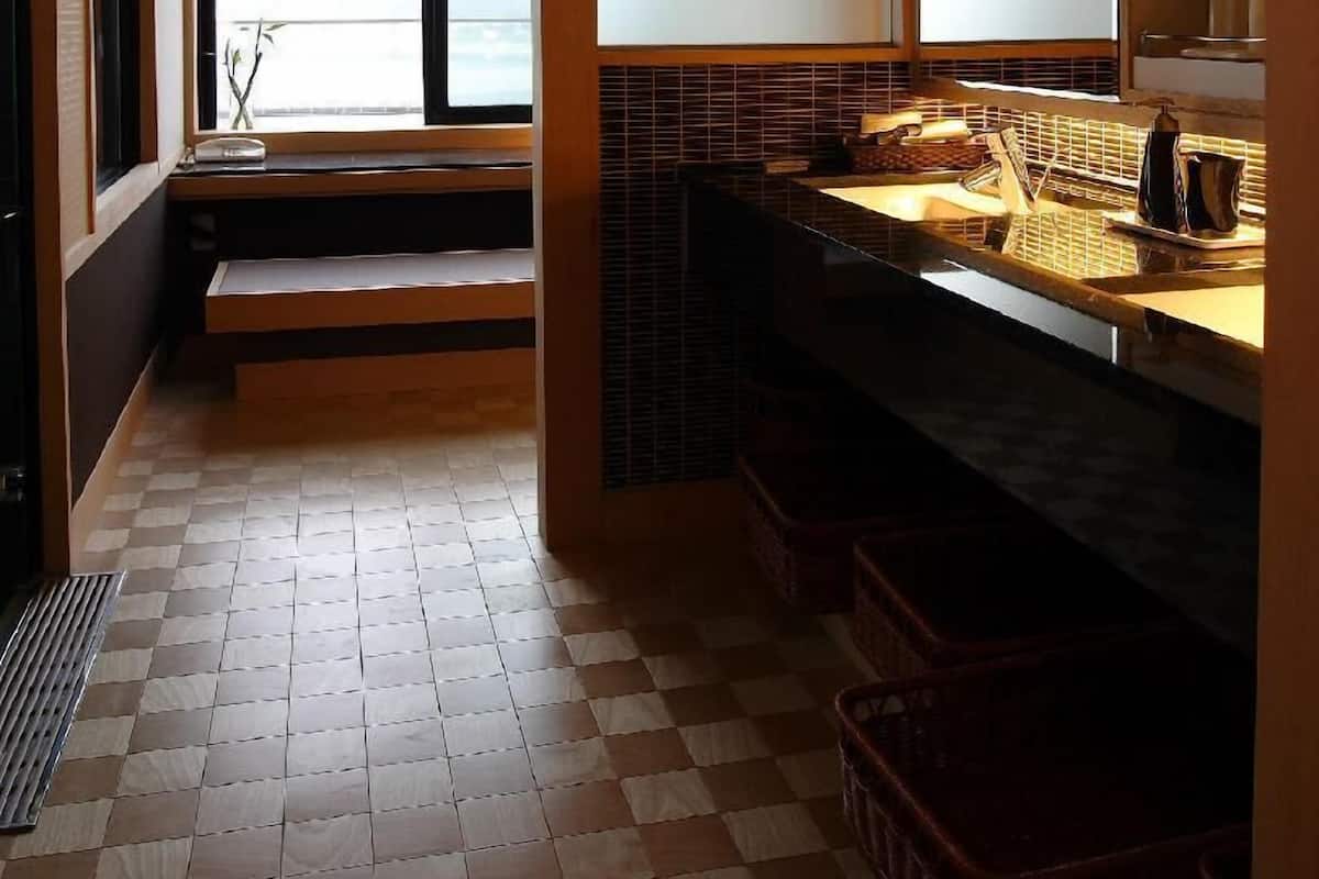 A bathroom with a window, a sink, and a mirror.