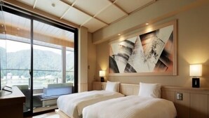 Una habitación de hotel con dos camas, un ventanal grande y un cuadro en la pared.