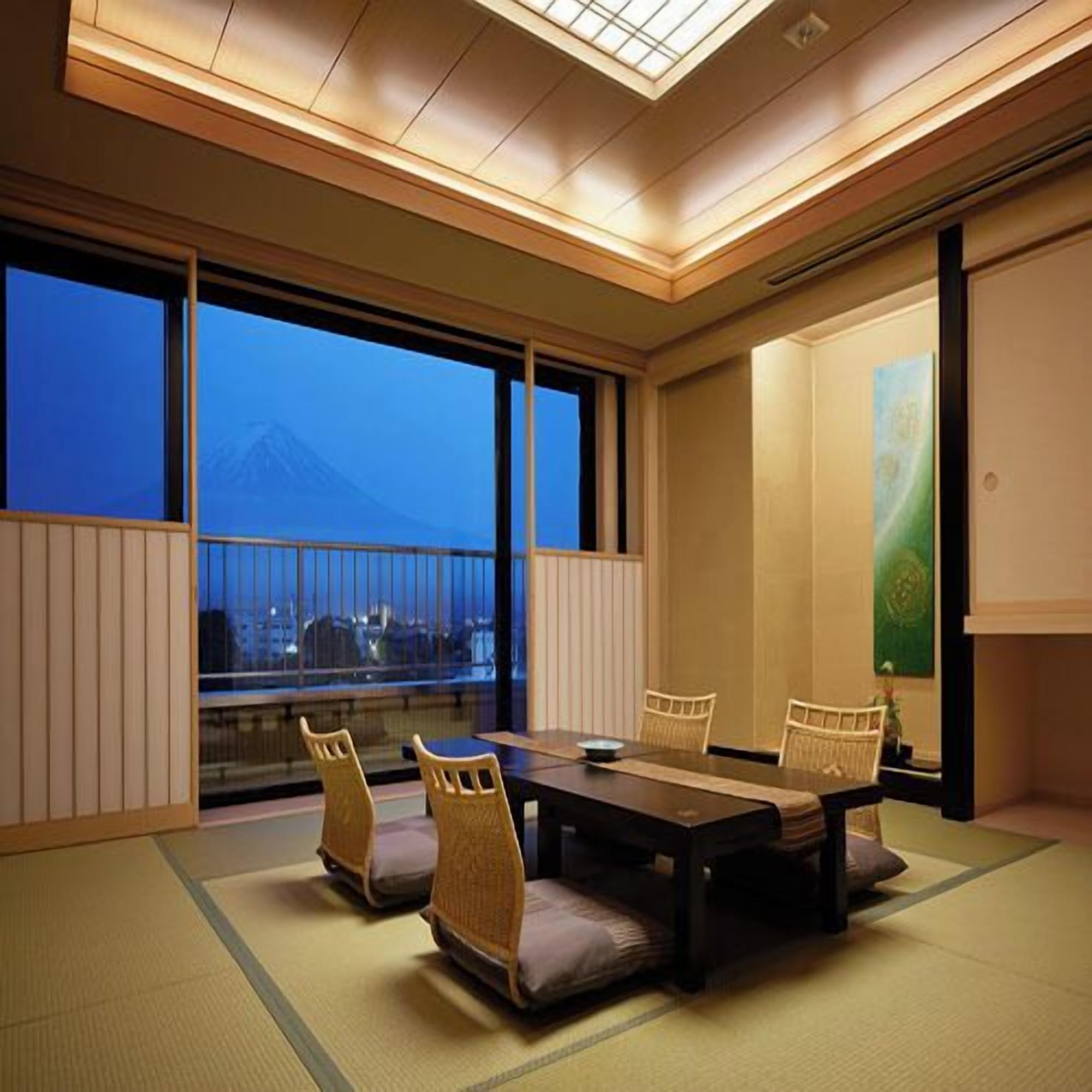 A traditional Japanese-style room with tatami flooring, a low table, and four chairs.