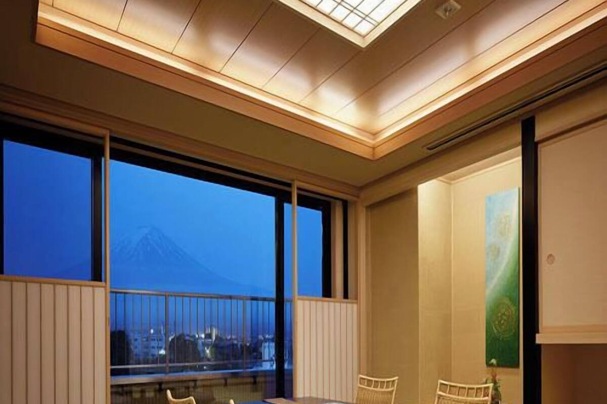 A traditional Japanese-style room with tatami flooring, a low table, and four chairs.