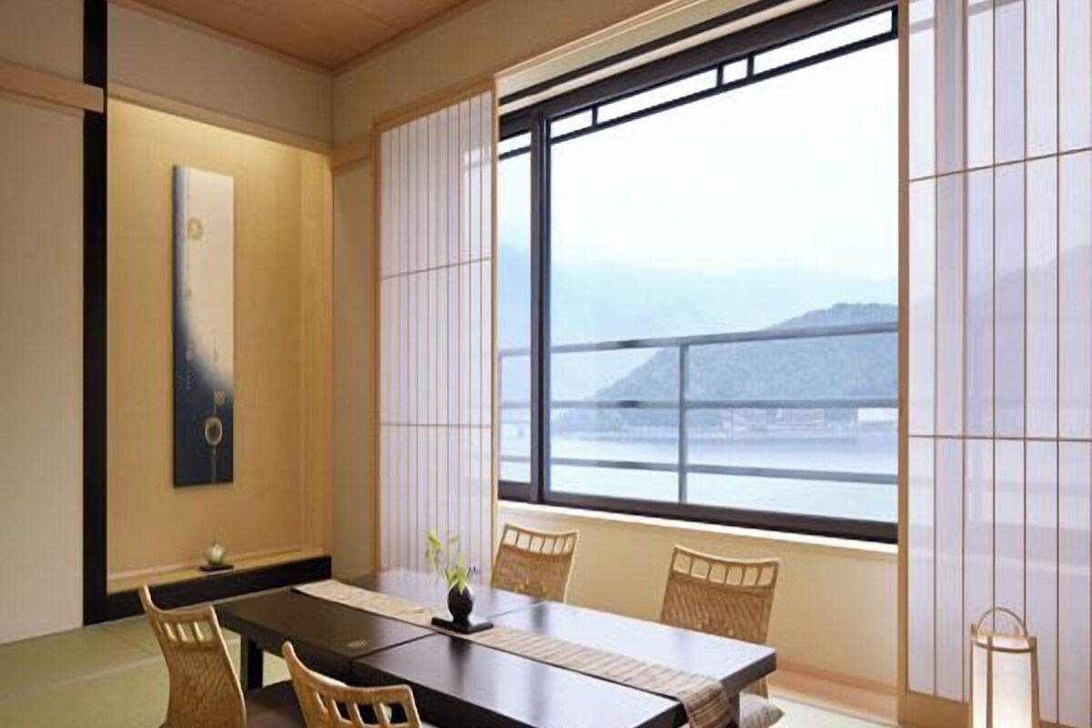 Une pièce de style japonais traditionnel, avec un sol recouvert de tatamis, une table basse et des paravents coulissants (shoji).