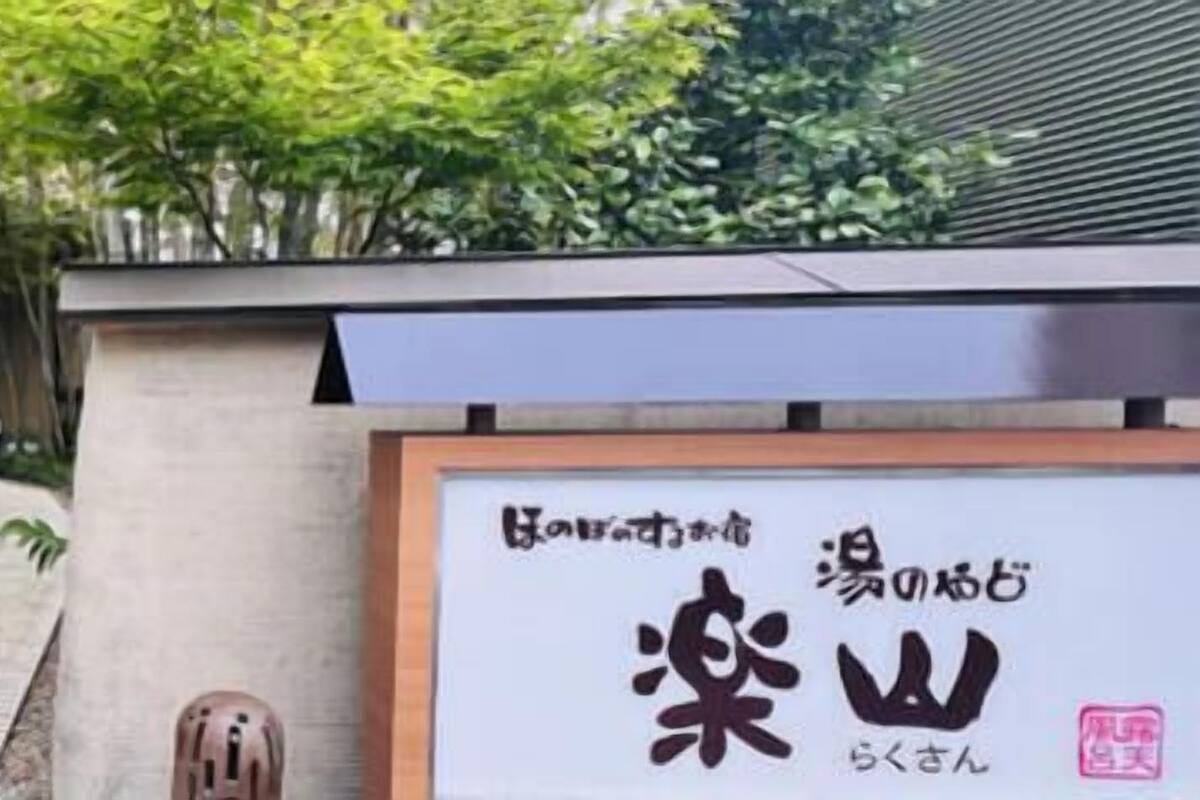 Un chemin menant à un bâtiment sur lequel est apposée une enseigne avec des caractères japonais.