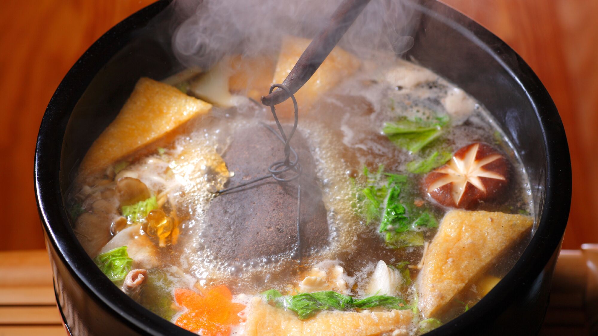 Um pote quente com vários ingredientes e vapor subindo.