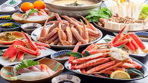 A variety of seafood dishes, including crab legs, on a table. - Kinosaki Onsen Restaurant & Ryokan Yoshiharu (Toyooka)