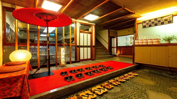 A traditional Japanese room with tatami flooring, a red carpet, and a row of sandals on the floor. - Kinosaki Onsen Restaurant & Ryokan Yoshiharu (Toyooka)