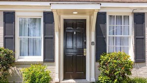 A house with a dark front door, white shutters, and a small porch. - Modern Interior - Delightful Doubles Unit D (Columbus)