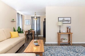Ein Wohnzimmer mit einer Couch, einem Couchtisch und einem 'welcome'-Schild.