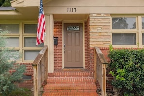 A house with a brown door, a brick exterior, and a number '1117' above the door. - 10 Min to Downtown, Close to Dining-Boxwood Beauty (Columbus)