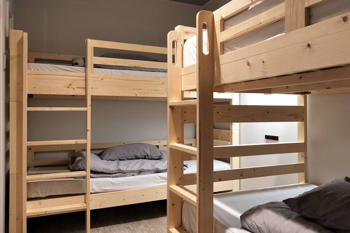 Quarto com beliche, escrivaninha e janela.