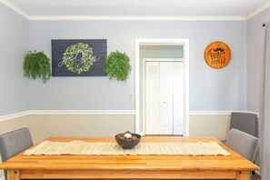 A dining area with a wooden table, a bowl of food, and a wall with a 'Bon Appetit' sign.