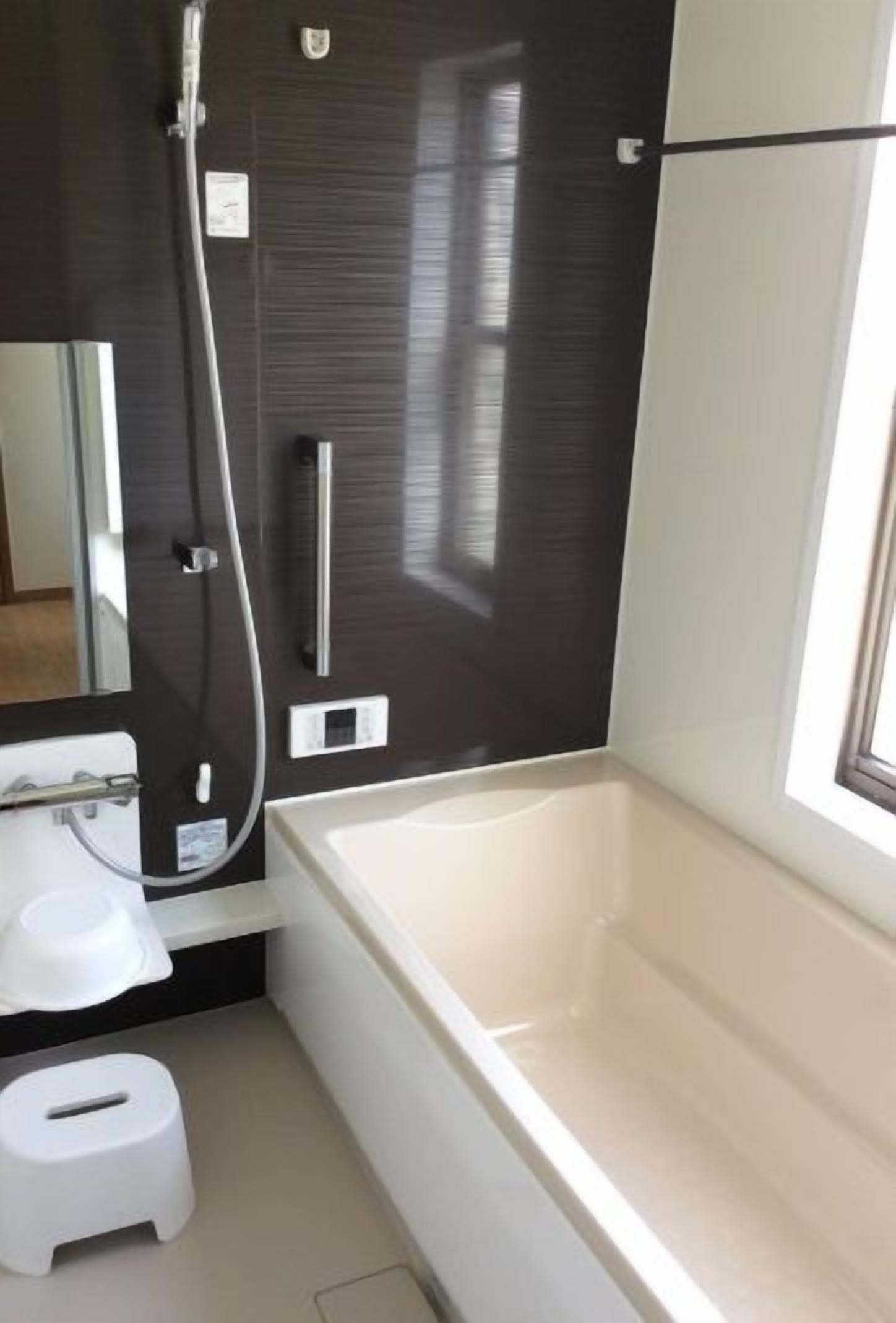 A modern bathroom with a bathtub, a shower, and a toilet.