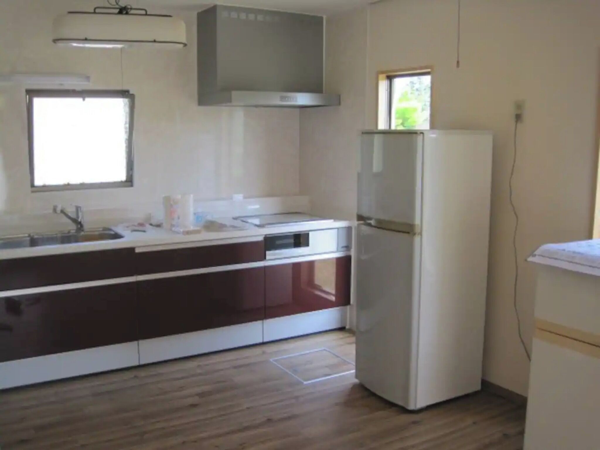 Una cocina con un refrigerador blanco, un lavamanos y un ventanal.