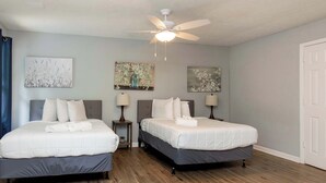 A bedroom with two beds, a ceiling fan, and artwork on the walls. - Pool, Fenced Yard, & Patio! Ventura Vista Retreat (Columbus)