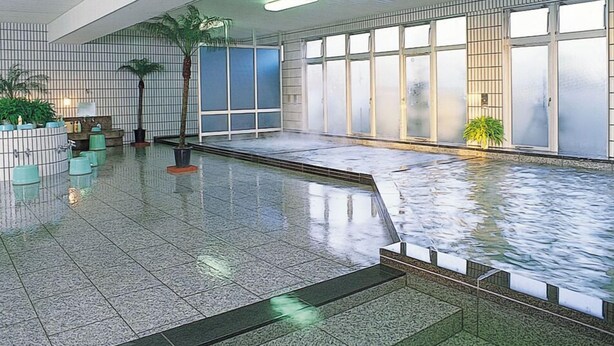 A spacious indoor pool area with tiled flooring, a seating area with chairs, and a large windowed wall. - Gekko Onsen Kua Haimu (Koriyama)