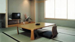 A traditional Japanese room with tatami flooring, a low table, a television, and a window with shoji screens. - Gekko Onsen Kua Haimu (Koriyama)