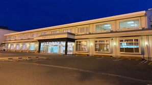 A multi-story hotel with a flat facade, large windows, and a parking lot in front. - Gekko Onsen Kua Haimu (Koriyama)