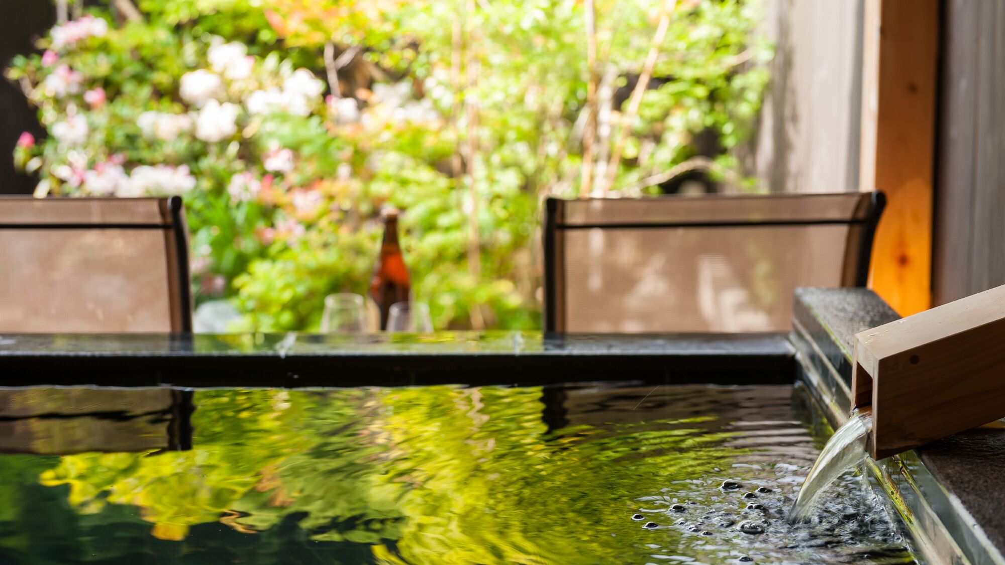 A water feature with a wooden structure, surrounded by greenery.