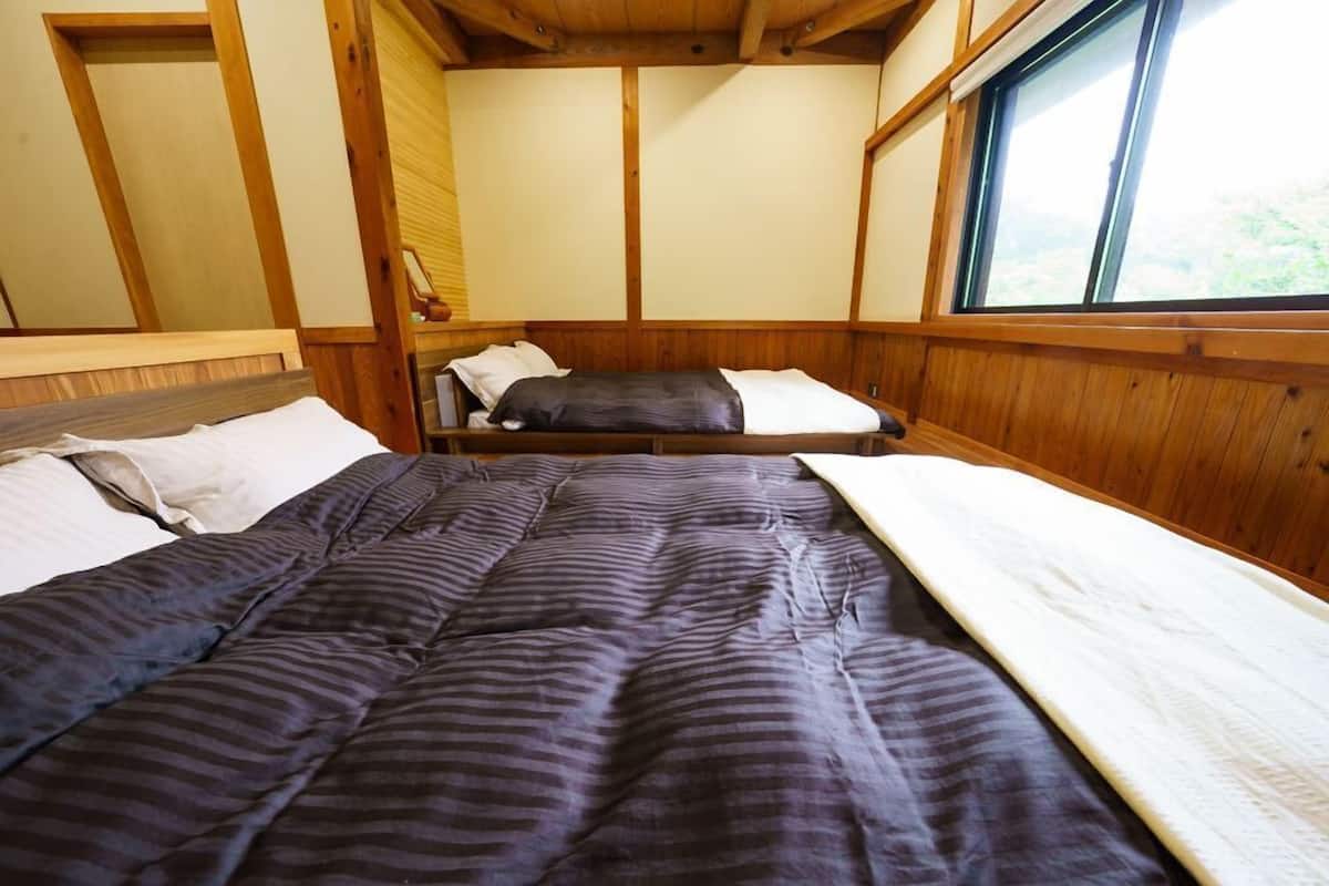 A room with a bed, a window, and wooden paneling.