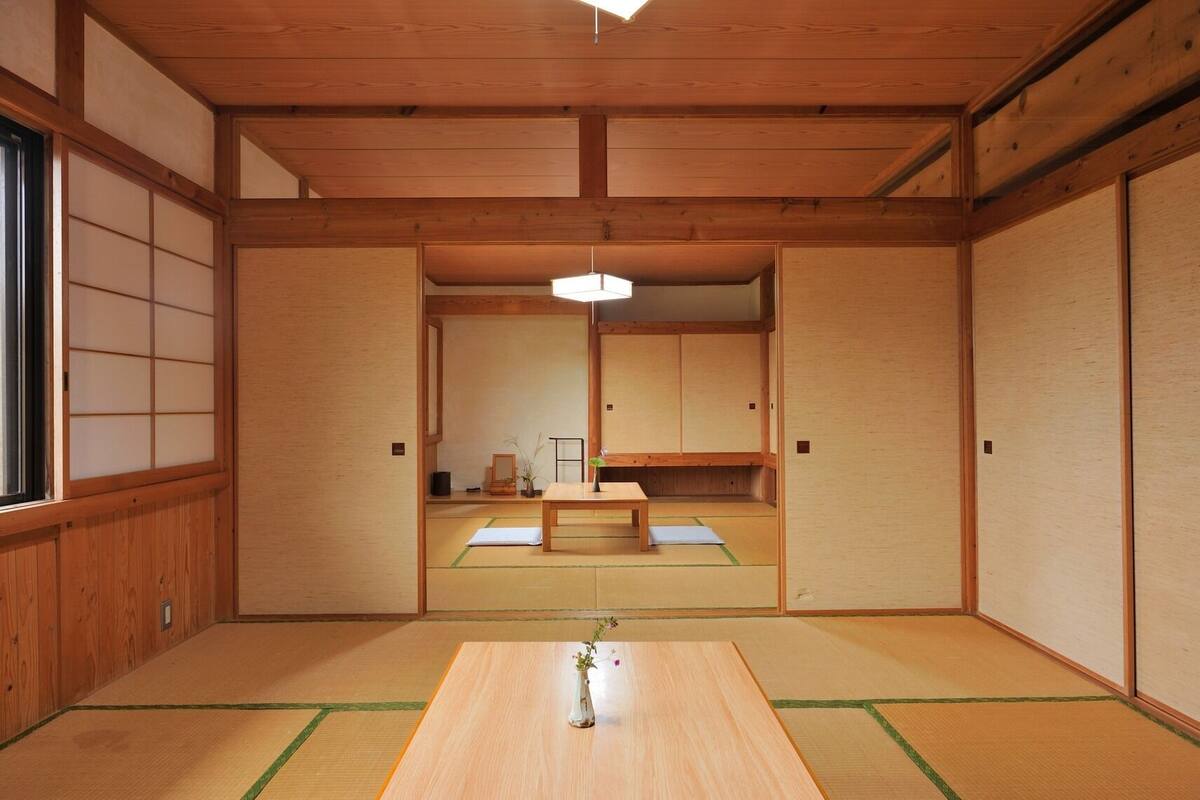 A traditional Japanese room with tatami flooring, a low wooden table, and sliding doors.