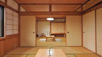 A traditional Japanese room with tatami flooring, a low wooden table, and sliding doors.