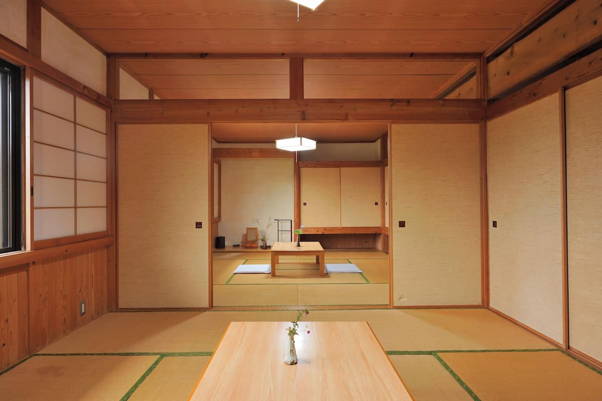 A traditional Japanese room with tatami flooring, a low wooden table, and sliding doors.