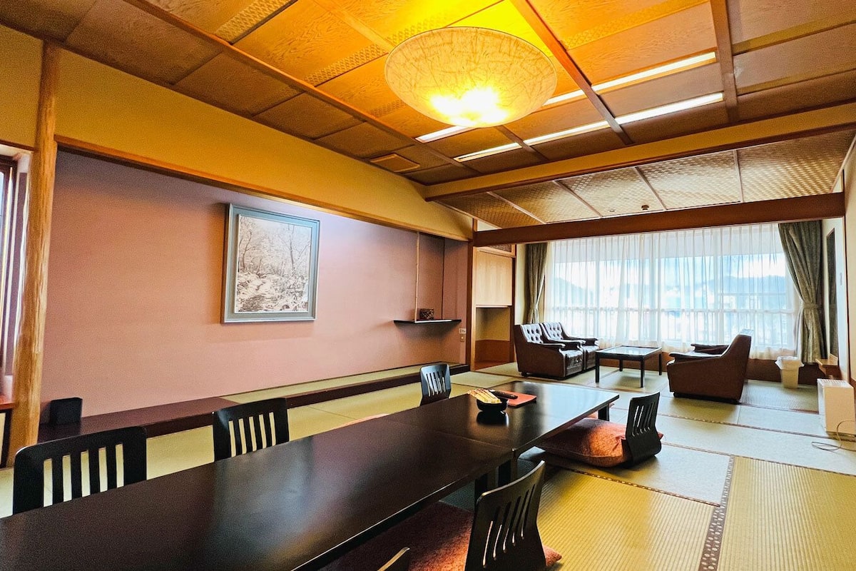 Une pièce de style japonais traditionnel, avec un sol recouvert de tatamis, une table basse et des assises confortables.