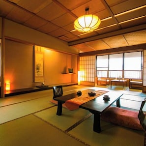 Um quarto japonês tradicional com tatames, uma mesa baixa, um banco e portas deslizantes.