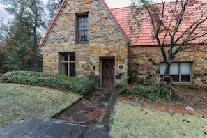 A stone house with a tiled roof, a front door, and a small window. - The Dinglewood Castle An Unparalleled Experience (Columbus)