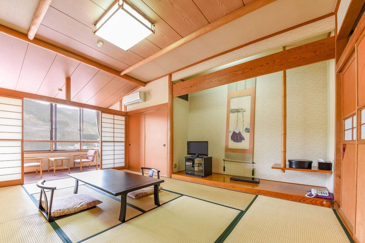 A traditional Japanese room with tatami flooring, a low table, and sliding doors.