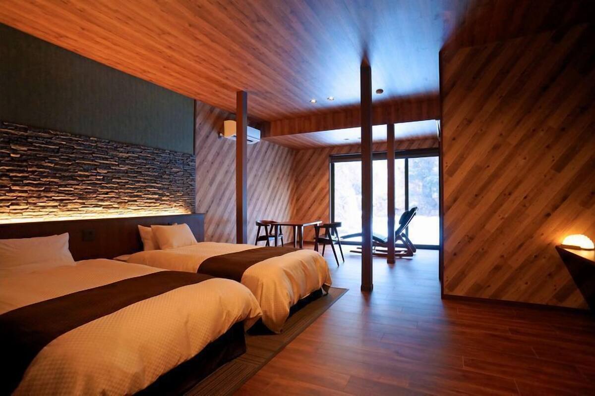 A modern hotel room with a large bed, a small table, and a chair.