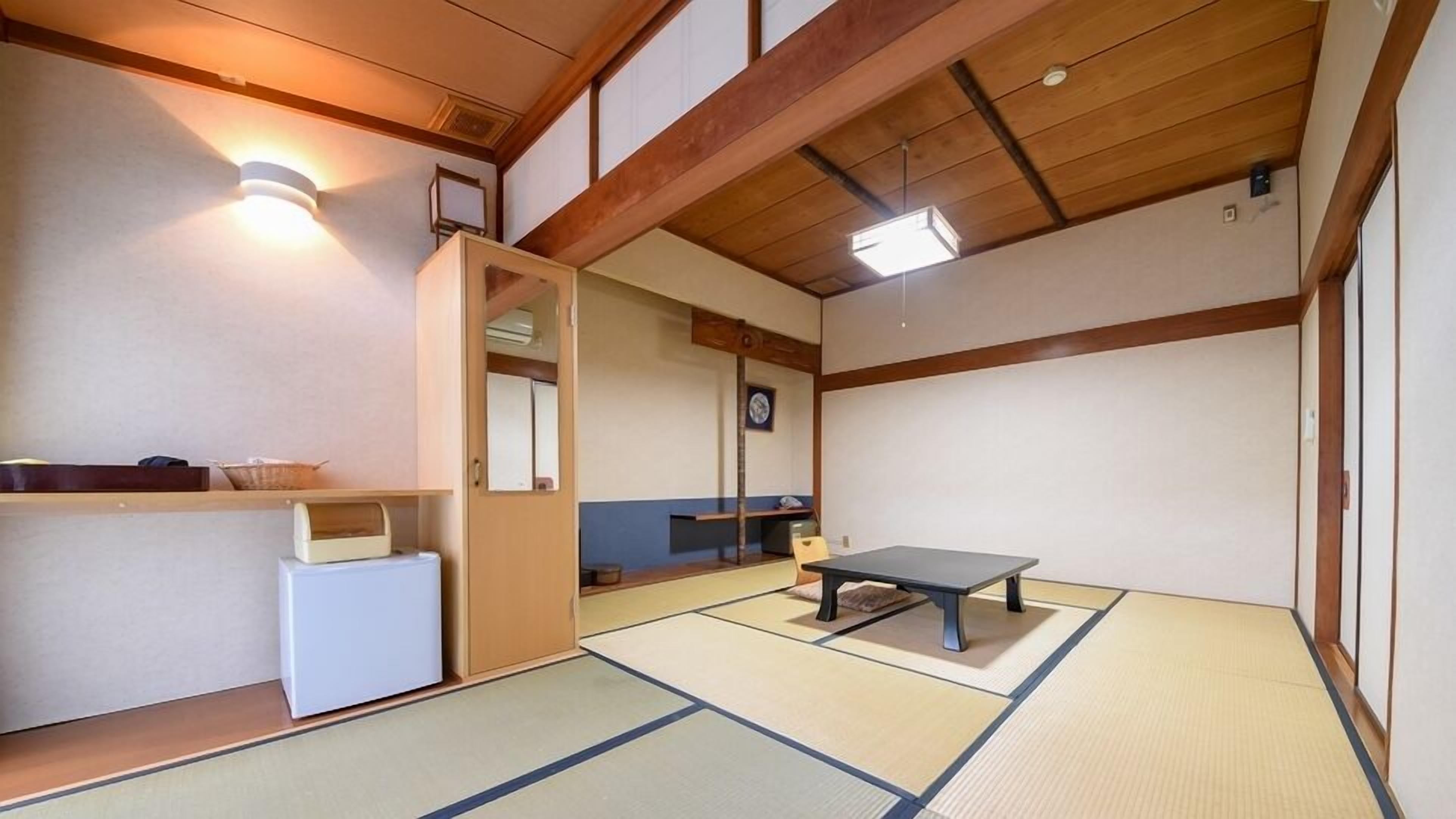 A traditional Japanese room with tatami flooring, a low table, a small cabinet, and a mirror.