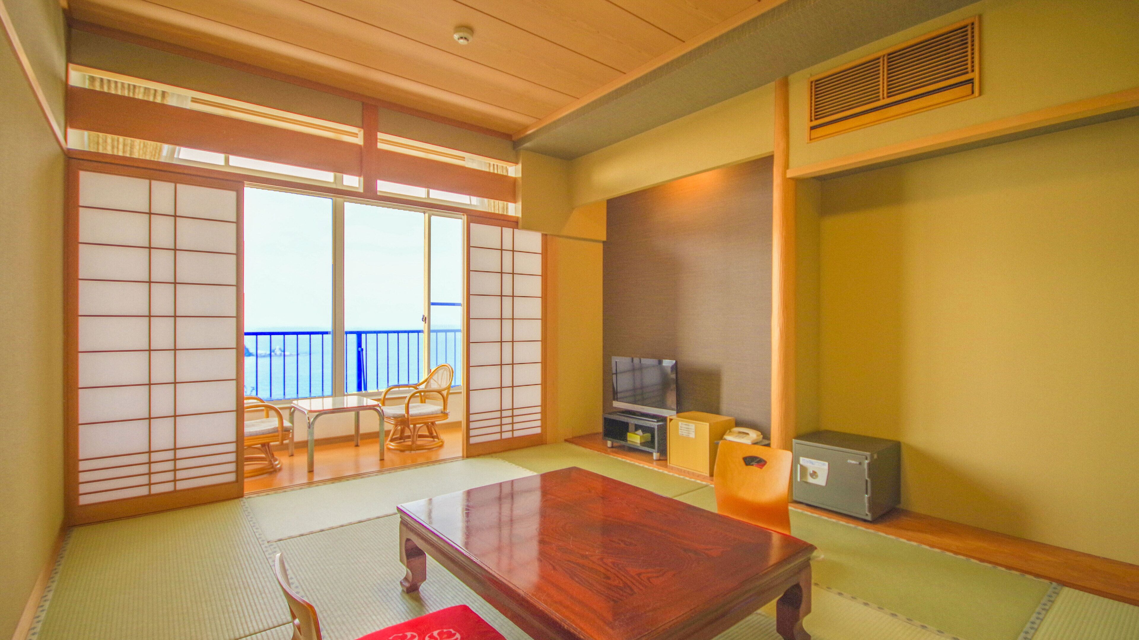 Een traditionele Japanse kamer met tatami vloerbedekking, een verschuifbare shoji-scherm, een televisie en een klein kastje.