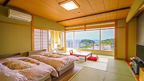 Una habitación con dos camas, televisión y vista al mar.